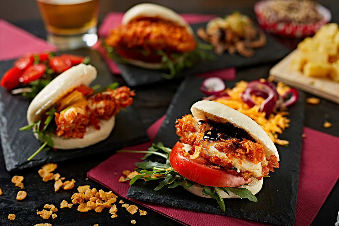 Fried chicken sliders with tomato, greens, and crisp onion sides